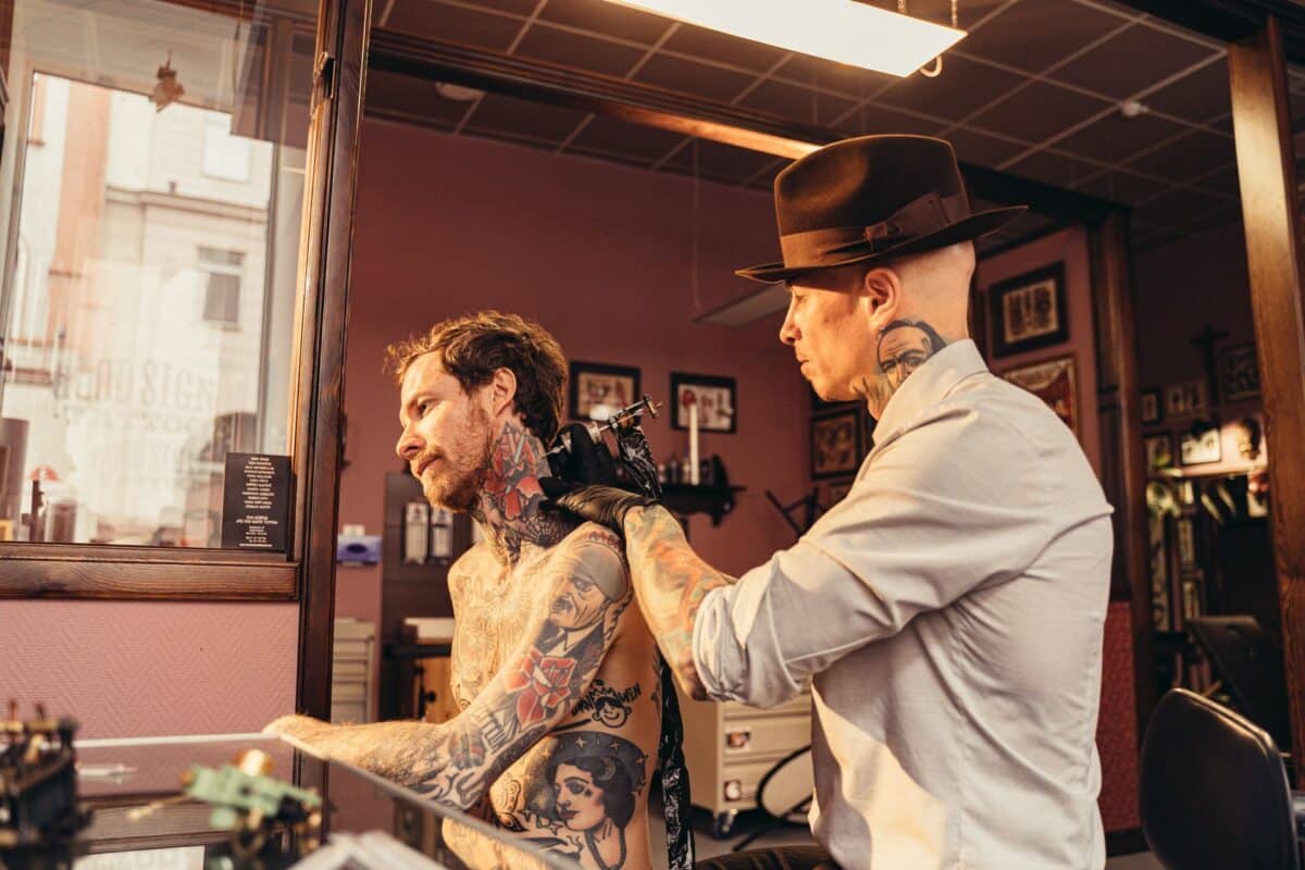 A Tattoo Artist working with a client in a studio